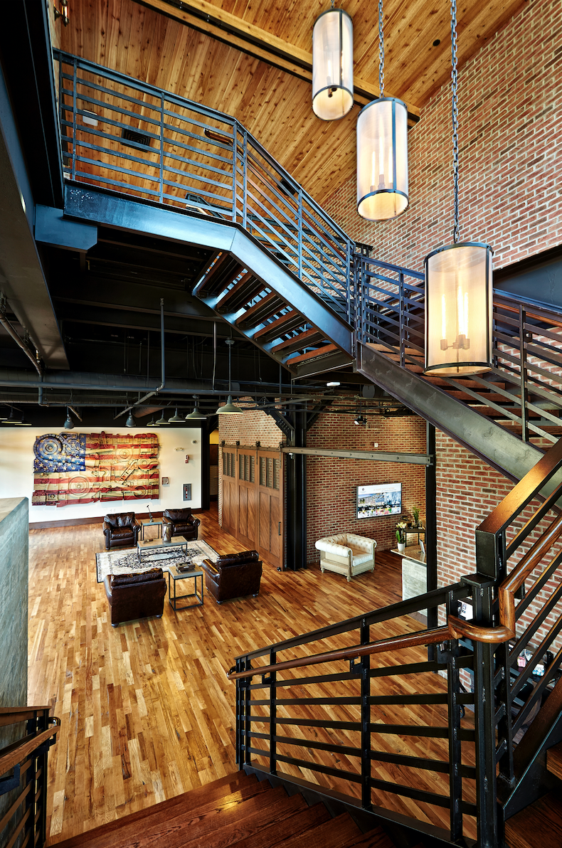 A wooden staircase with a metal railing leads to the upper floor of a house.